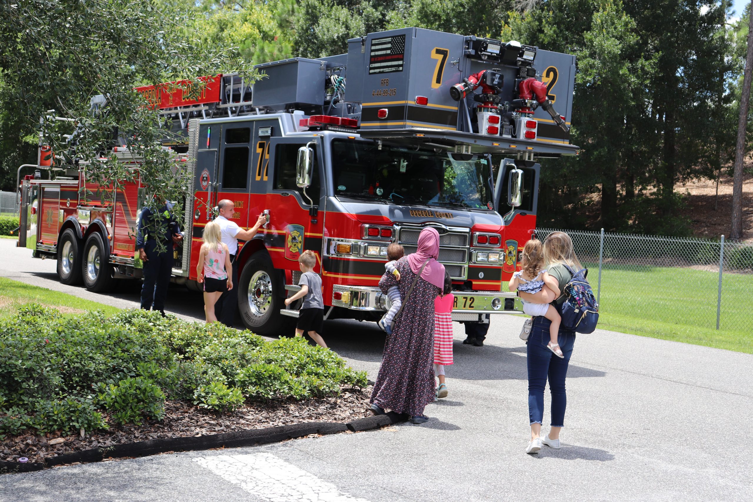 Families gather around a parked fire truck.