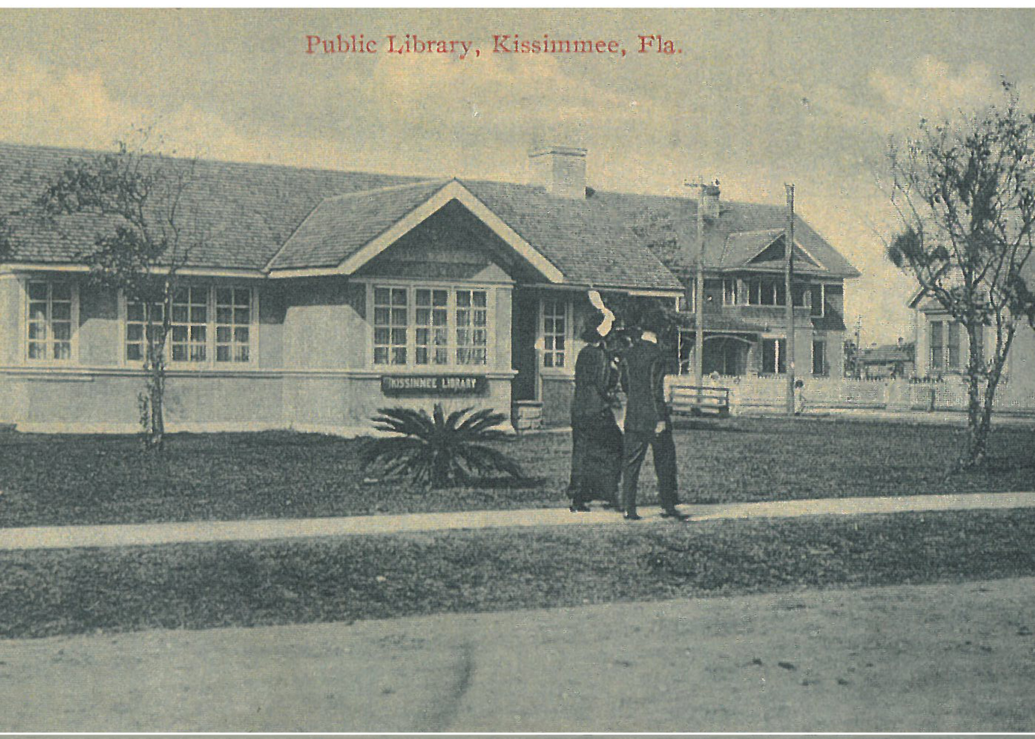 An old, yellowed photograph of a building. Two people walk on the sidewalk in front. Caption reads "Public Library, Kissimmee, FLA."